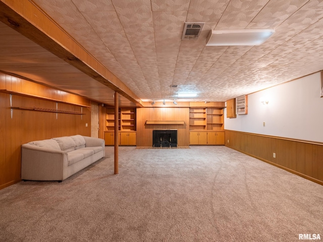204 Ivanhoe Way, Bloomington, IL 61701 - unfurnished living room with a tiled fireplace, carpet, wooden walls, and a wainscoted wall