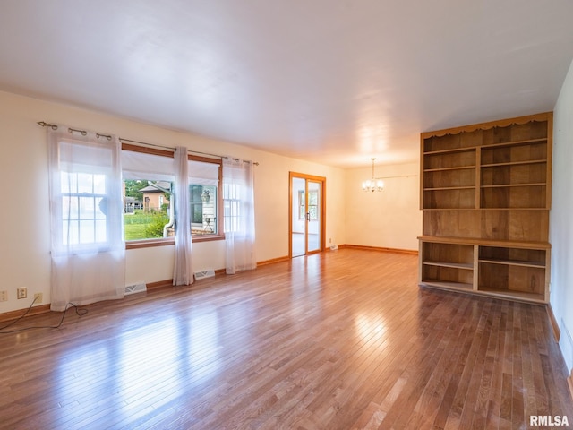 204 Ivanhoe Way, Bloomington, IL 61701 - unfurnished living room featuring a chandelier and wood finished floors
