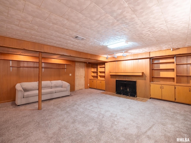 204 Ivanhoe Way, Bloomington, IL 61701 - unfurnished living room with wooden walls, carpet flooring, a fireplace with flush hearth, and track lighting