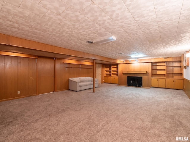 204 Ivanhoe Way, Bloomington, IL 61701 - unfurnished living room featuring wood walls, carpet floors, and a tiled fireplace