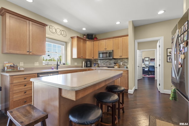 10615 N Collett Rd, Peoria, IL 61615 - kitchen with appliances with stainless steel finishes, light countertops, a breakfast bar, recessed lighting, and dark wood-style floors