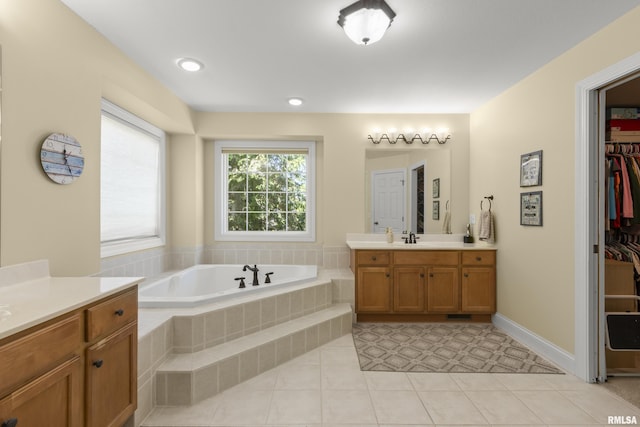 10615 N Collett Rd, Peoria, IL 61615 - bathroom featuring two vanities, a bath, tile patterned flooring, and a spacious closet