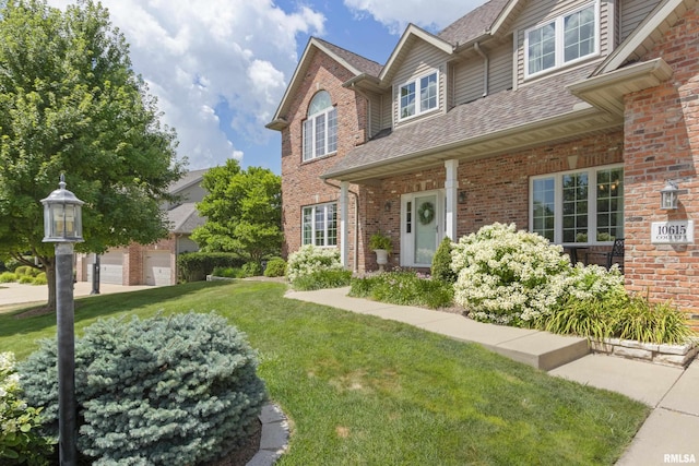 10615 N Collett Rd, Peoria, IL 61615 - traditional-style home featuring a front yard, brick siding, a garage, and roof with shingles