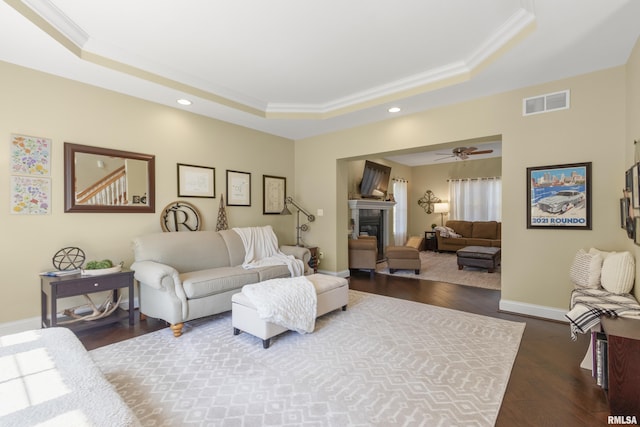 10615 N Collett Rd, Peoria, IL 61615 - living area with a tray ceiling, ornamental molding, dark wood-type flooring, recessed lighting, and a glass covered fireplace