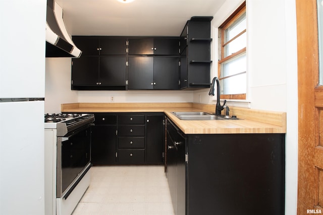416 W Maple St, Chillicothe, IL 61523 - kitchen featuring white appliances, wall chimney exhaust hood, dark cabinets, open shelves, and light flooring