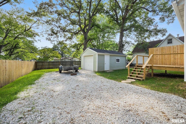 117 Hazel Ct, Creve Coeur, IL 61610 - fenced backyard with an outdoor structure, a wooden deck, a detached garage, and driveway