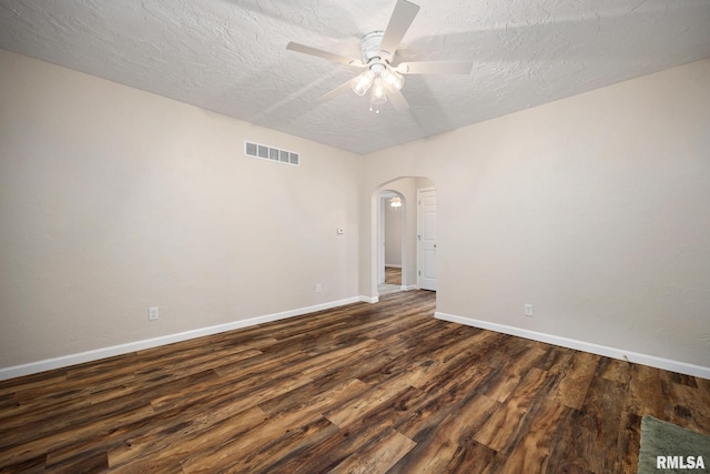 117 Hazel Ct, Creve Coeur, IL 61610 - empty room featuring arched walkways, dark wood finished floors, a ceiling fan, and a textured ceiling