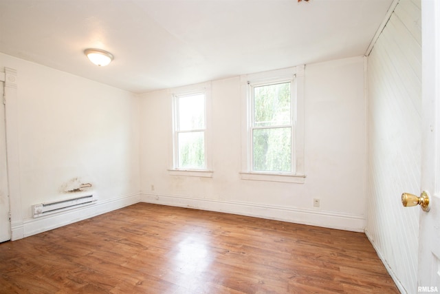 2211 N Bigelow St, Peoria, IL 61604 - unfurnished room featuring a baseboard heating unit and wood finished floors