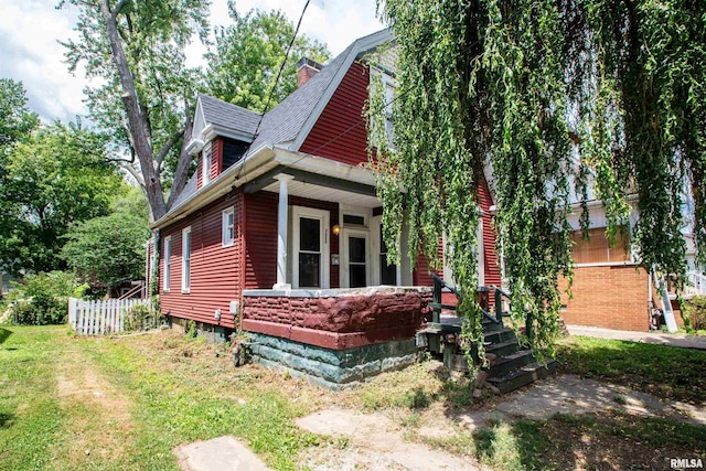 2211 N Bigelow St, Peoria, IL 61604 - view of side of home featuring a porch, roof with shingles, and a chimney