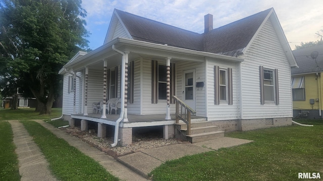 658 E Maple St, Canton, IL 61520 - view of home's exterior with a porch, a chimney, a yard, and a shingled roof