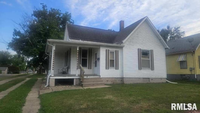 658 E Maple St, Canton, IL 61520 - view of front facade featuring covered porch, a front yard, a chimney, and a shingled roof