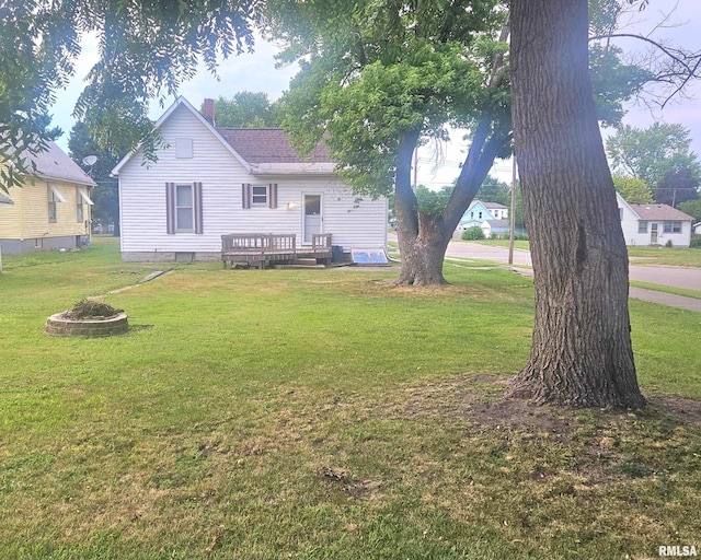 658 E Maple St, Canton, IL 61520 - back of property featuring a chimney, a yard, and a wooden deck