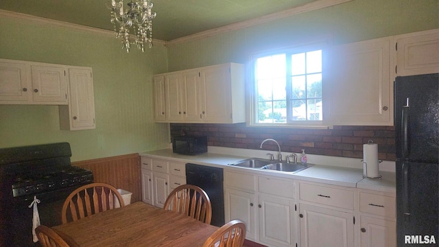 658 E Maple St, Canton, IL 61520 - kitchen with black appliances, white cabinetry, crown molding, light countertops, and wainscoting