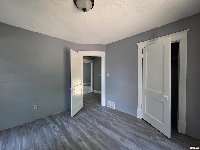 1310 N Sheridan Rd, Peoria, IL 61606 - unfurnished bedroom with dark wood finished floors and a textured ceiling