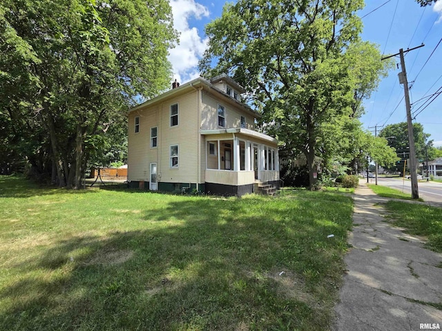 1310 N Sheridan Rd, Peoria, IL 61606 - view of side of property featuring a sunroom, a yard, and a chimney