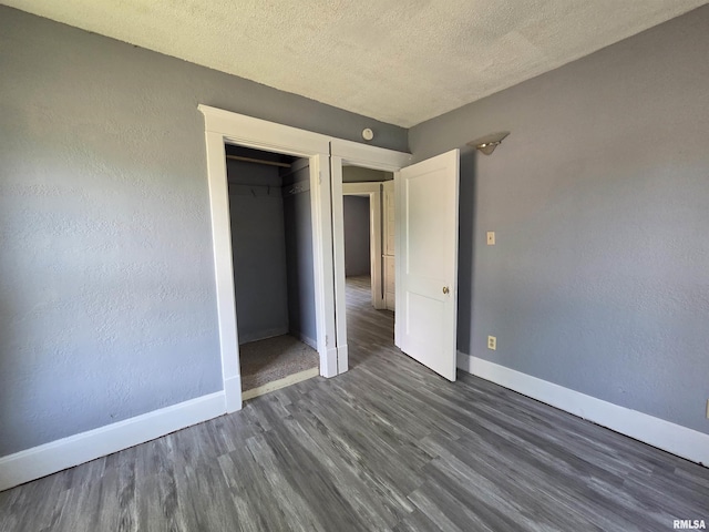1310 N Sheridan Rd, Peoria, IL 61606 - unfurnished bedroom featuring dark wood finished floors, a textured ceiling, and a closet