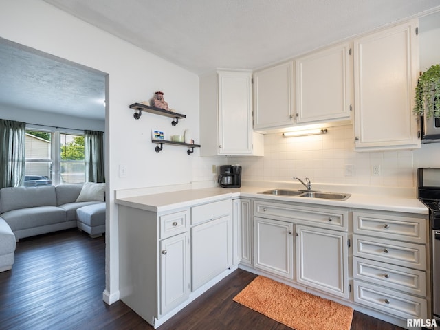 6110 N Idlewhile Dr, Peoria, IL 61614 - kitchen with dark wood-style floors, light countertops, tasteful backsplash, stainless steel range, and white cabinets