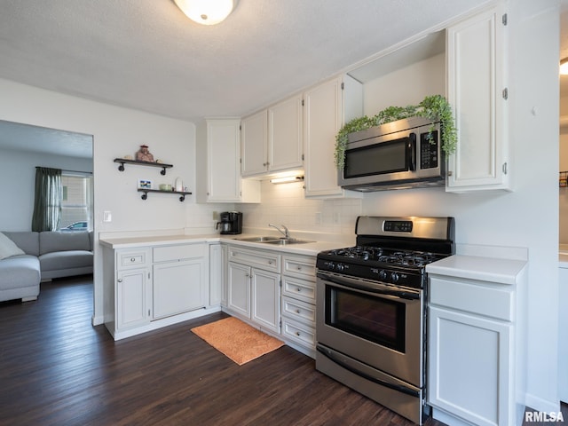 6110 N Idlewhile Dr, Peoria, IL 61614 - kitchen featuring appliances with stainless steel finishes, open shelves, dark wood finished floors, white cabinetry, and light countertops