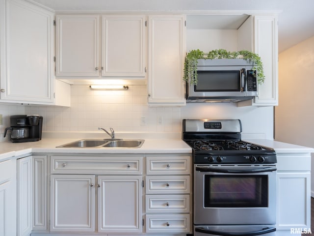 6110 N Idlewhile Dr, Peoria, IL 61614 - kitchen with appliances with stainless steel finishes, white cabinetry, light countertops, and backsplash