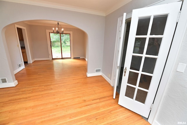 300 E Embert Pl, Peoria, IL 61603 - spare room with arched walkways, a chandelier, light wood-style flooring, and ornamental molding