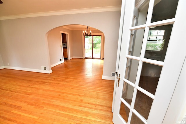 300 E Embert Pl, Peoria, IL 61603 - unfurnished room with arched walkways, crown molding, wood finished floors, and a chandelier