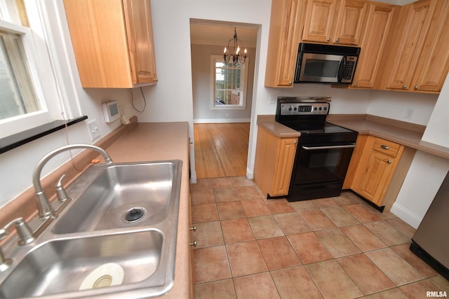 300 E Embert Pl, Peoria, IL 61603 - kitchen featuring black electric range oven, a chandelier, light tile patterned floors, and light countertops