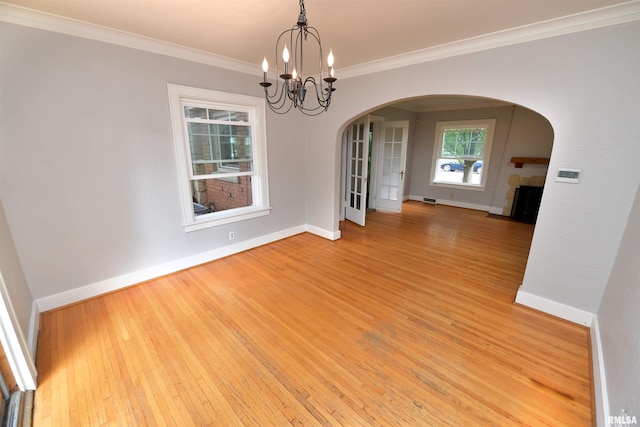 300 E Embert Pl, Peoria, IL 61603 - spare room with arched walkways, a chandelier, wood finished floors, ornamental molding, and a fireplace