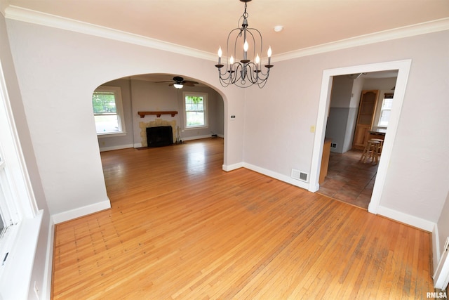 300 E Embert Pl, Peoria, IL 61603 - unfurnished dining area with arched walkways, crown molding, light wood-style flooring, a fireplace with flush hearth, and ceiling fan