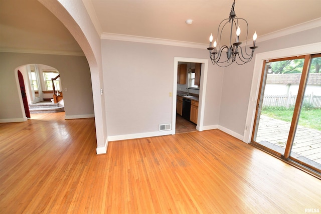 300 E Embert Pl, Peoria, IL 61603 - empty room with arched walkways, light wood-style flooring, ornamental molding, and a chandelier