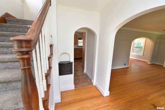300 E Embert Pl, Peoria, IL 61603 - foyer entrance featuring crown molding, arched walkways, stairs, and wood finished floors