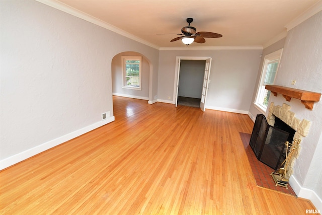 300 E Embert Pl, Peoria, IL 61603 - unfurnished living room with a fireplace with flush hearth, light wood-type flooring, ceiling fan, arched walkways, and crown molding