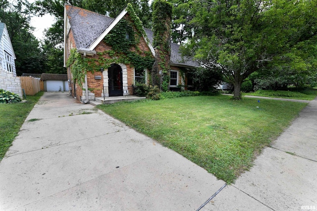 300 E Embert Pl, Peoria, IL 61603 - tudor home with brick siding, a high end roof, concrete driveway, an outdoor structure, and a detached garage
