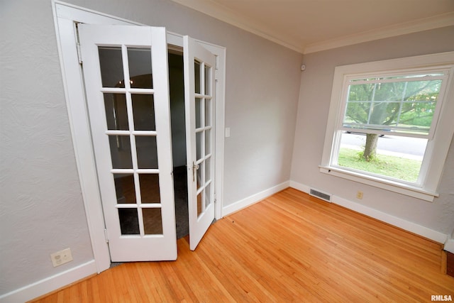 300 E Embert Pl, Peoria, IL 61603 - empty room featuring light wood-style floors, crown molding, and french doors