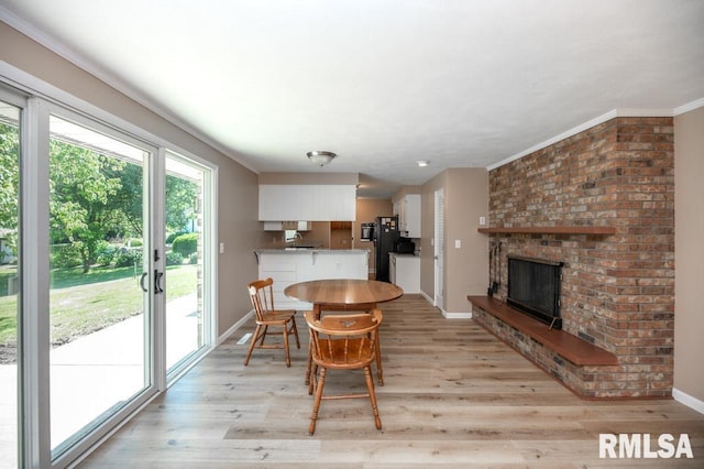 470 E Hazelwood St, Morton, IL 61550 - dining room featuring light wood-style flooring, a fireplace, and crown molding