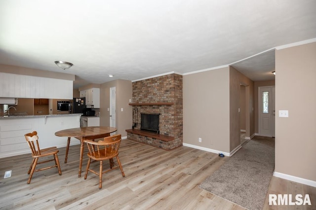 470 E Hazelwood St, Morton, IL 61550 - dining space featuring light wood finished floors, a fireplace, and crown molding