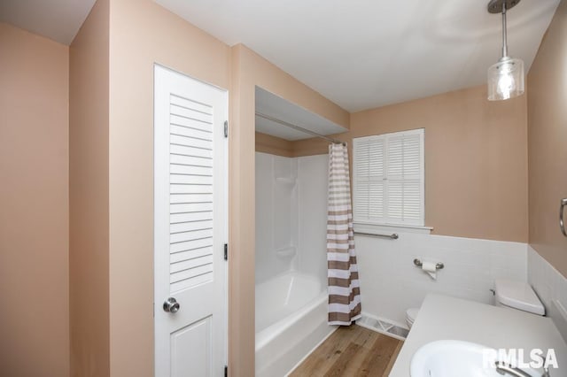 470 E Hazelwood St, Morton, IL 61550 - full bath featuring wood finished floors, shower / tub combo, tile walls, and a wainscoted wall