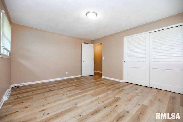470 E Hazelwood St, Morton, IL 61550 - unfurnished bedroom featuring crown molding, light wood-style flooring, and a closet