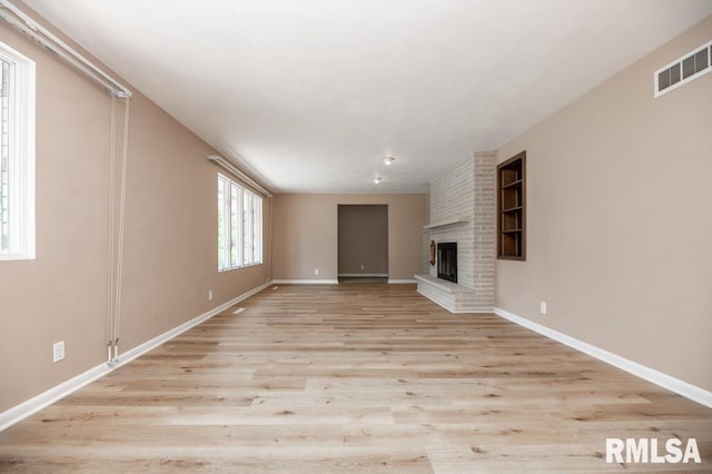 470 E Hazelwood St, Morton, IL 61550 - unfurnished living room with light wood-type flooring and a brick fireplace