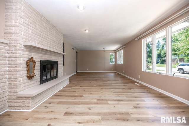 470 E Hazelwood St, Morton, IL 61550 - unfurnished living room with a brick fireplace and light wood-type flooring
