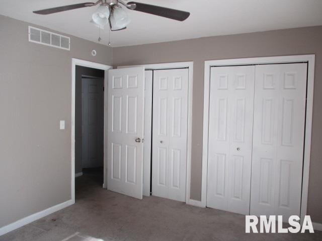 203 Arrow St, Pekin, IL 61554 - unfurnished bedroom featuring multiple closets, carpet flooring, and a ceiling fan