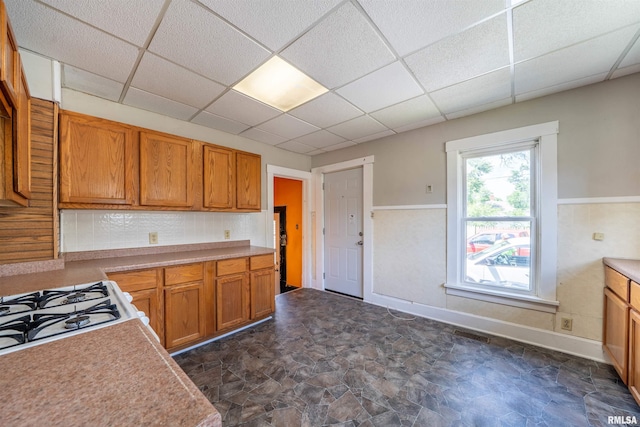 339 Herman St, Pekin, IL 61554 - kitchen featuring a paneled ceiling, stone finish flooring, light countertops, brown cabinets, and cooktop