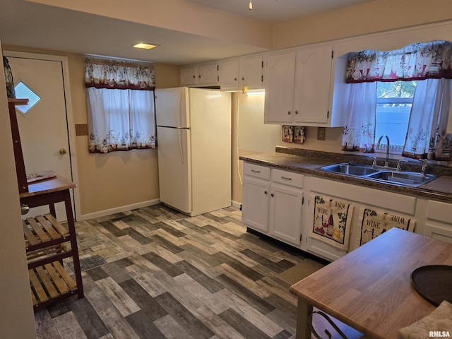 403 Koch St, Pekin, IL 61554 - kitchen featuring freestanding refrigerator, dark wood-style floors, white cabinets, and dark countertops