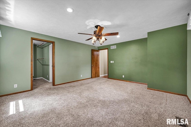 303 W 3rd Ave, Deer Creek, IL 61733 - unfurnished bedroom with carpet floors, a walk in closet, a textured ceiling, a ceiling fan, and recessed lighting
