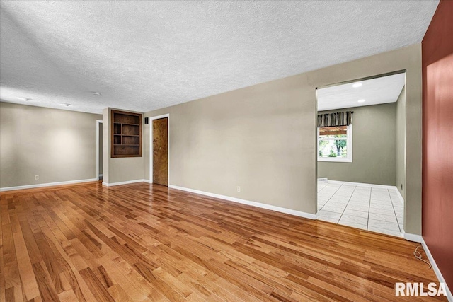 303 W 3rd Ave, Deer Creek, IL 61733 - empty room featuring light wood finished floors and a textured ceiling