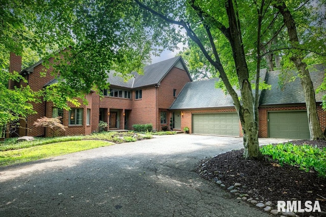 408 W Ravinwoods Rd, Peoria, IL 61615 - view of front of house featuring asphalt driveway, an attached garage, brick siding, and a shingled roof