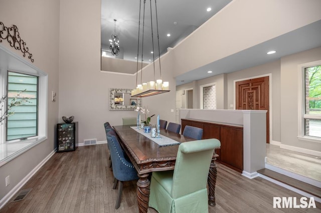 408 W Ravinwoods Rd, Peoria, IL 61615 - dining room with a chandelier, wood finished floors, a high ceiling, and recessed lighting