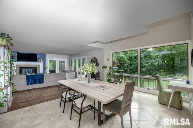 408 W Ravinwoods Rd, Peoria, IL 61615 - dining space featuring light tile patterned flooring, healthy amount of natural light, and a glass covered fireplace
