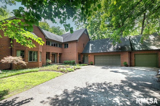 408 W Ravinwoods Rd, Peoria, IL 61615 - view of front facade featuring an attached garage, asphalt driveway, brick siding, and roof with shingles