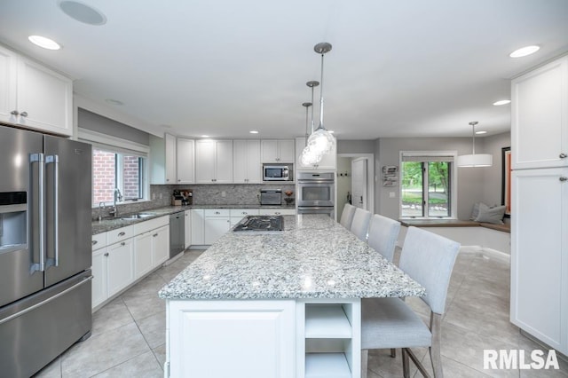 408 W Ravinwoods Rd, Peoria, IL 61615 - kitchen featuring stainless steel appliances, plenty of natural light, light tile patterned flooring, and recessed lighting