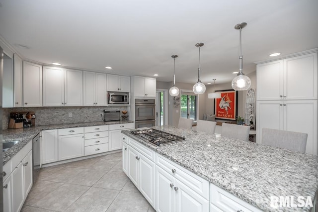 408 W Ravinwoods Rd, Peoria, IL 61615 - kitchen with decorative backsplash, white cabinetry, light tile patterned flooring, stainless steel appliances, and light stone counters